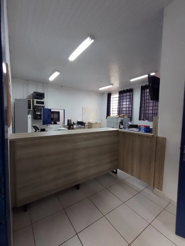 Balcão de recepção planejado em MDF claro com tampo em L e armários laterais