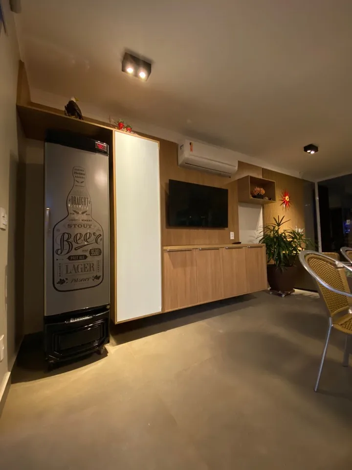 Rack suspenso e painel de TV em madeira com nichos decorativos e parede ripada ao fundo